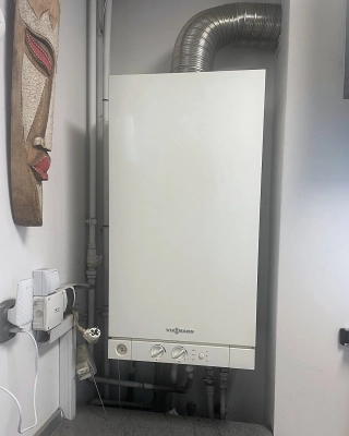 Stary atmosferyczny kocioł gazowy Viessmann z aluminiowym przewodem spalinowym przed wymianą we Wrocławiu